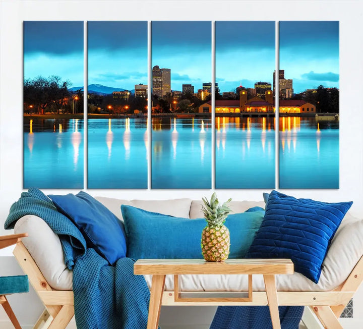 A living room in teal and brown decor showcases the "Denver City Lights Night Bright Turquoise Skyline Cityscape View" wall art canvas print above the couch. This large, museum-quality piece comes with a UV-protective coating.