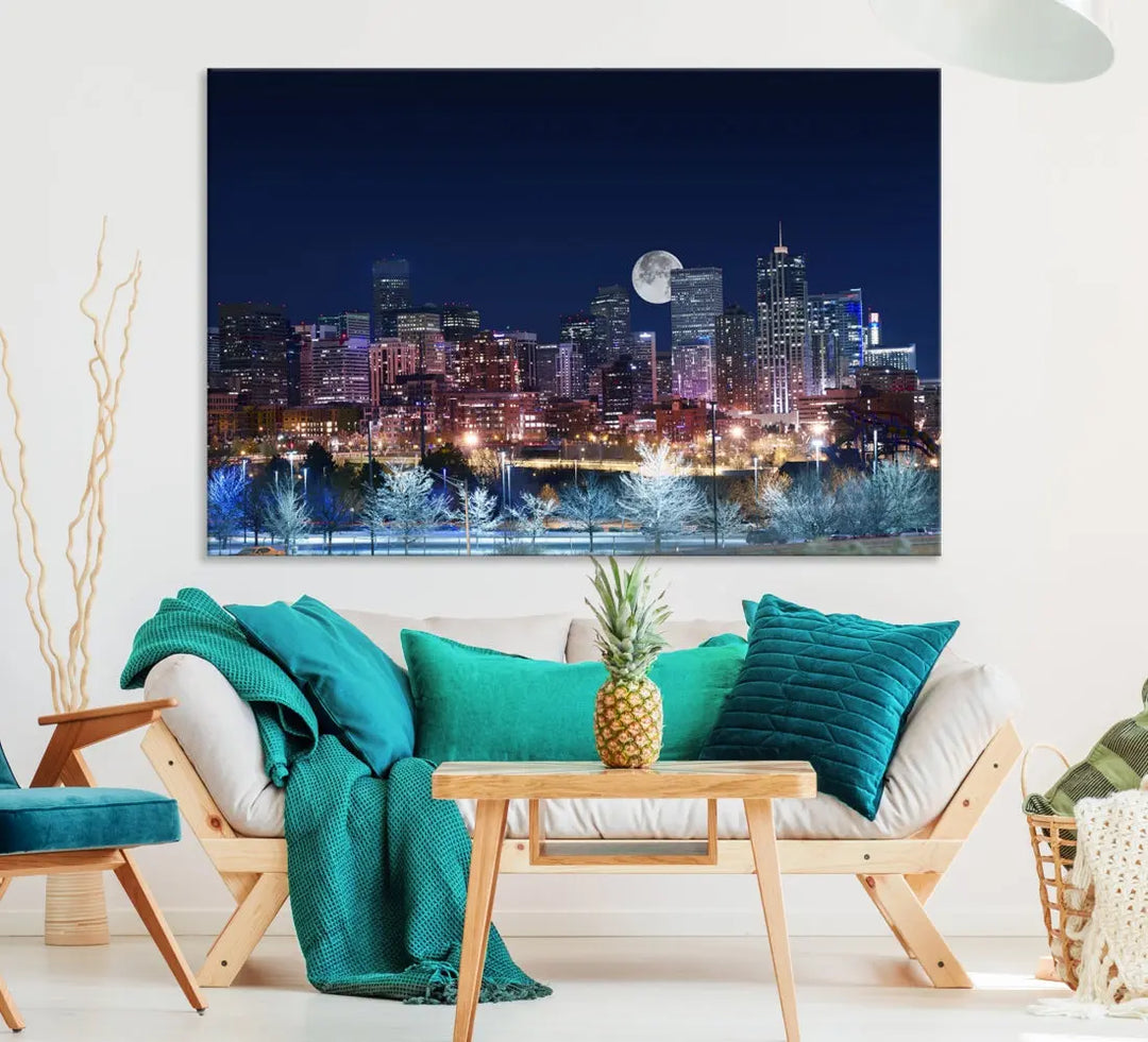 A cozy living room features the "Denver City Lights Night with Full Moon Skyline Cityscape View" wall art canvas print, gallery wrapped on museum-quality canvas.