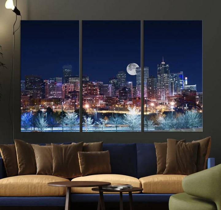 A cozy living room features the "Denver City Lights Night with Full Moon Skyline Cityscape View" wall art canvas print, gallery wrapped on museum-quality canvas.