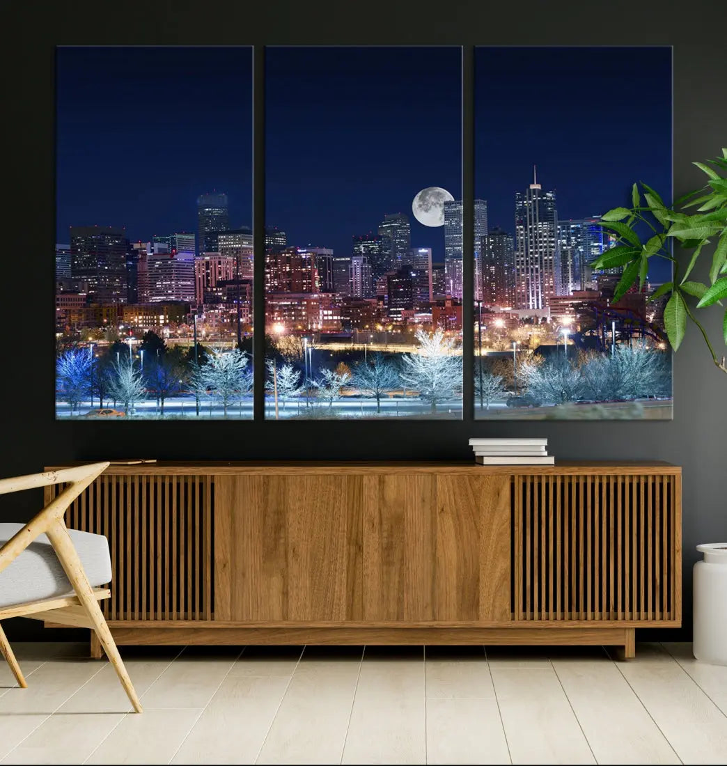 A cozy living room features the "Denver City Lights Night with Full Moon Skyline Cityscape View" wall art canvas print, gallery wrapped on museum-quality canvas.