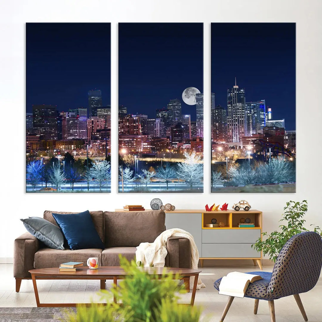 A cozy living room features the "Denver City Lights Night with Full Moon Skyline Cityscape View" wall art canvas print, gallery wrapped on museum-quality canvas.