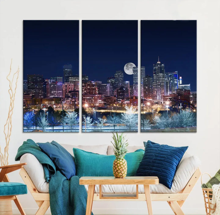 A cozy living room features the "Denver City Lights Night with Full Moon Skyline Cityscape View" wall art canvas print, gallery wrapped on museum-quality canvas.