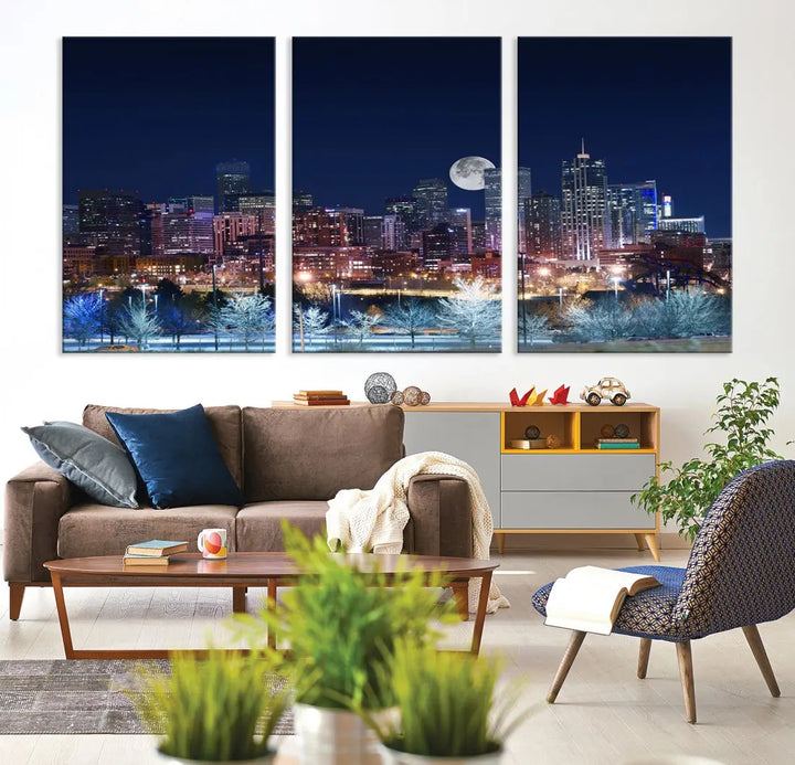 A cozy living room features the "Denver City Lights Night with Full Moon Skyline Cityscape View" wall art canvas print, gallery wrapped on museum-quality canvas.