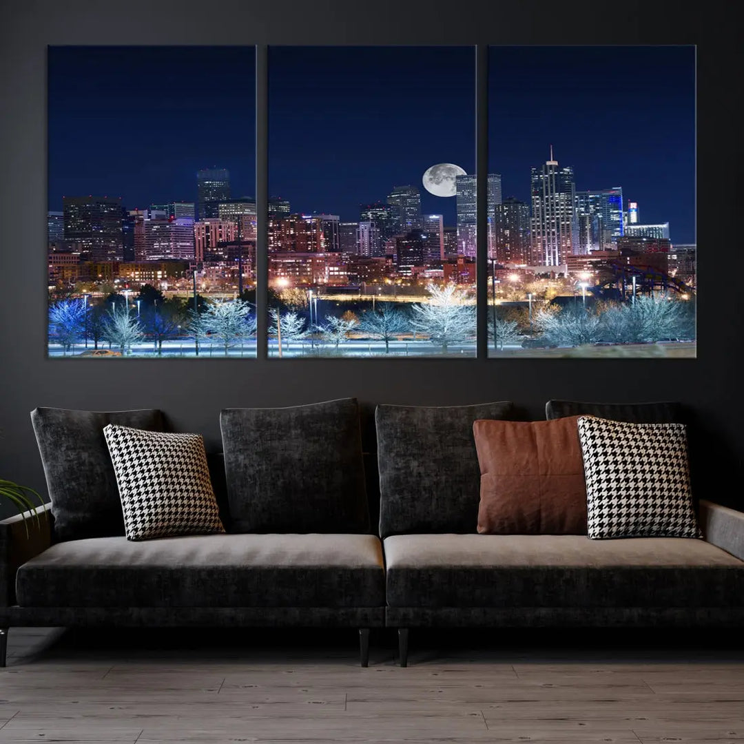 A cozy living room features the "Denver City Lights Night with Full Moon Skyline Cityscape View" wall art canvas print, gallery wrapped on museum-quality canvas.