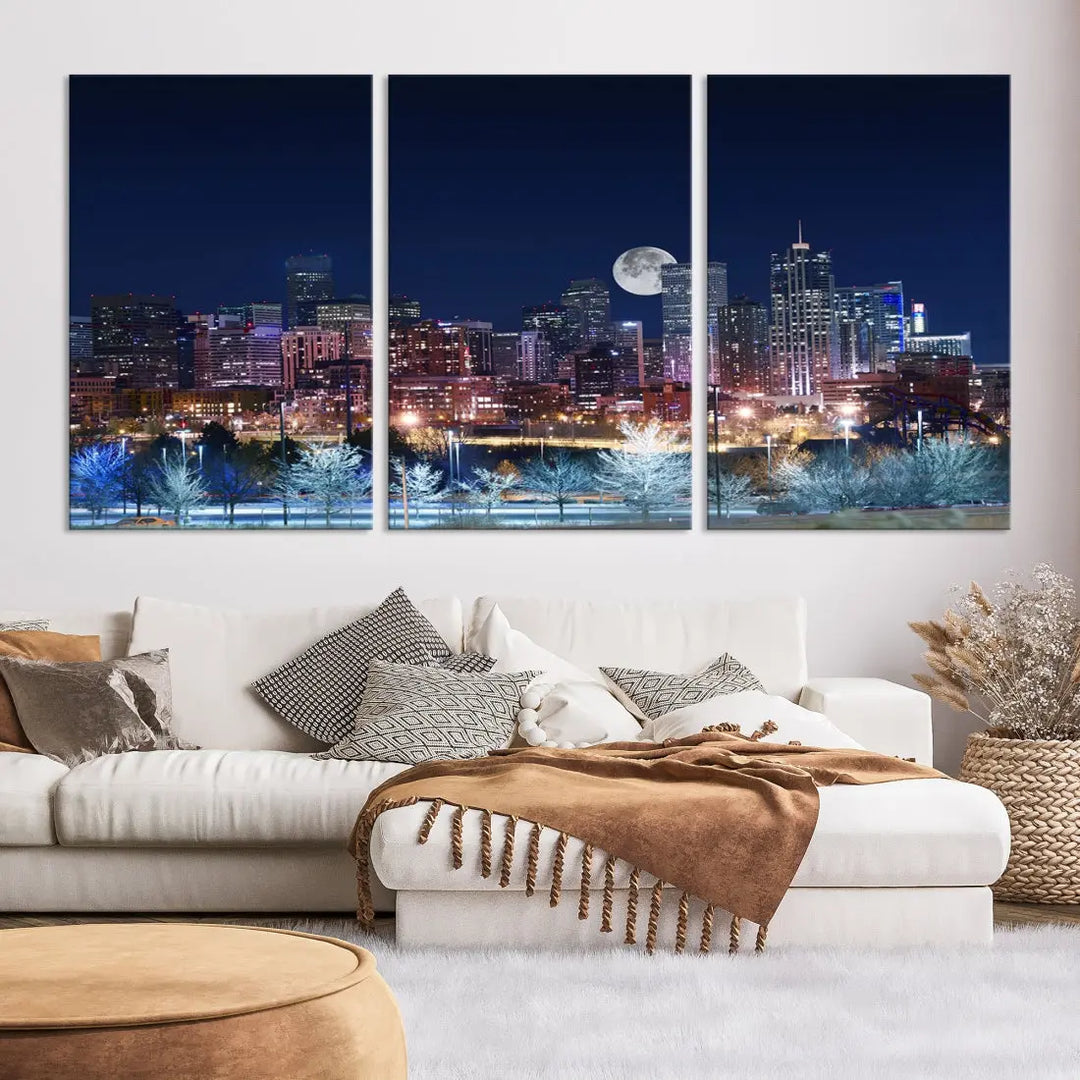 A cozy living room features the "Denver City Lights Night with Full Moon Skyline Cityscape View" wall art canvas print, gallery wrapped on museum-quality canvas.