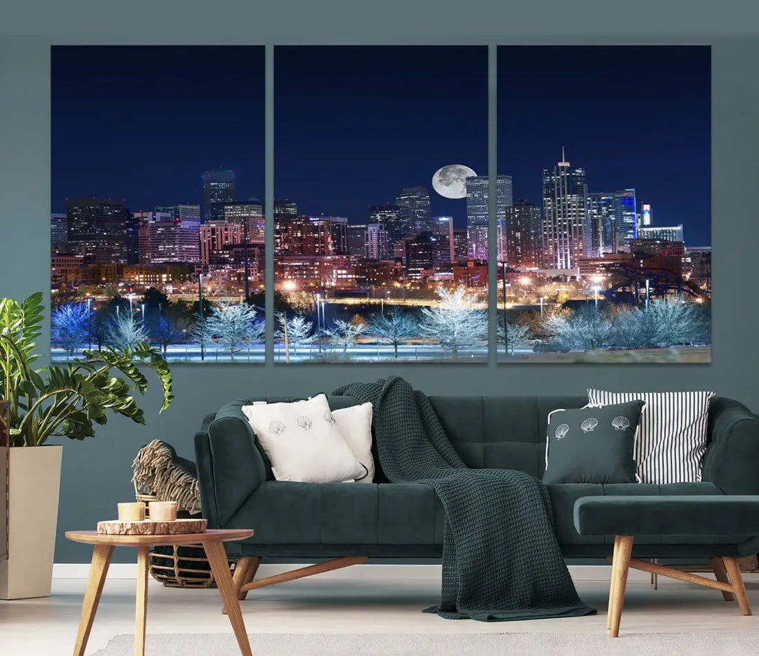 A cozy living room features the "Denver City Lights Night with Full Moon Skyline Cityscape View" wall art canvas print, gallery wrapped on museum-quality canvas.