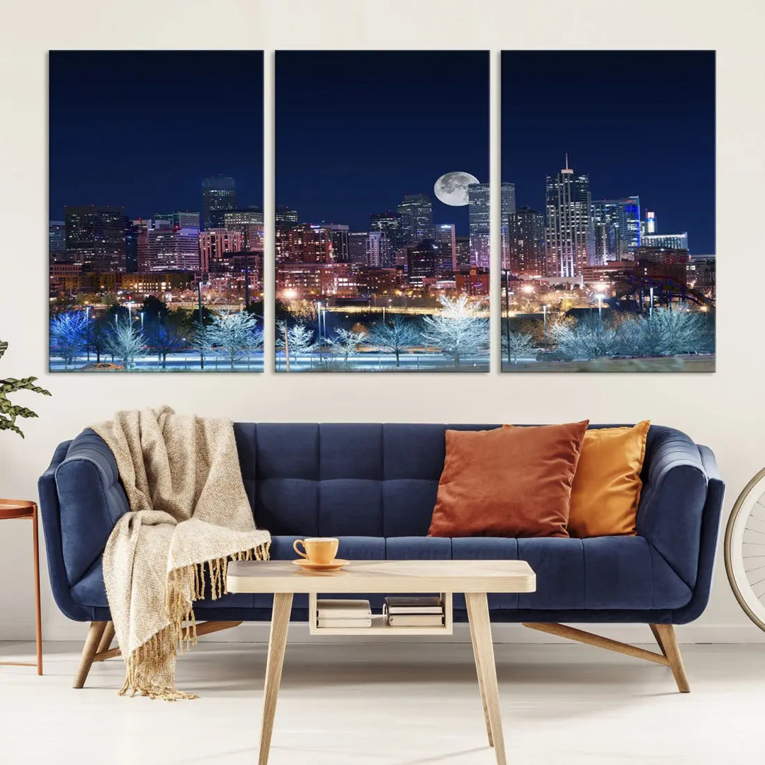 A cozy living room features the "Denver City Lights Night with Full Moon Skyline Cityscape View" wall art canvas print, gallery wrapped on museum-quality canvas.