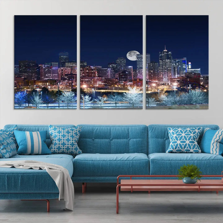 A cozy living room features the "Denver City Lights Night with Full Moon Skyline Cityscape View" wall art canvas print, gallery wrapped on museum-quality canvas.