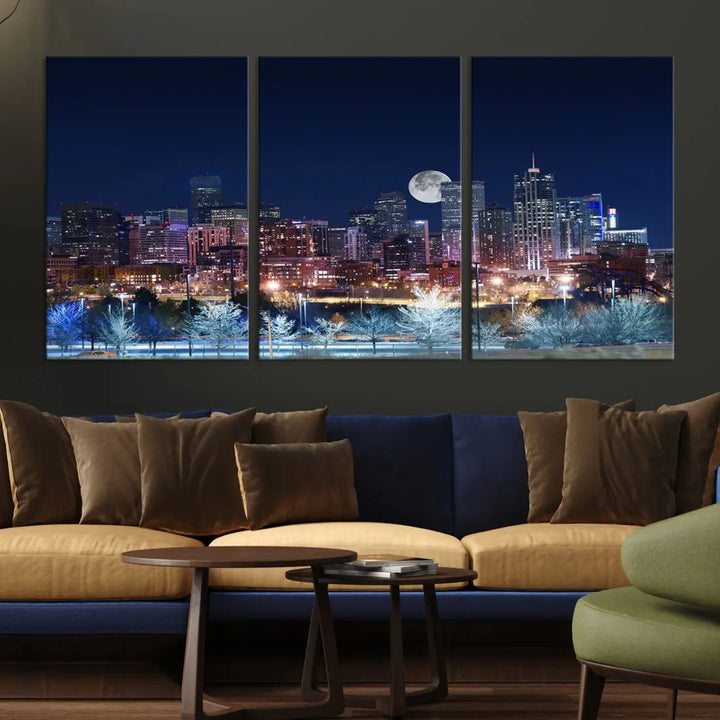 A cozy living room features the "Denver City Lights Night with Full Moon Skyline Cityscape View" wall art canvas print, gallery wrapped on museum-quality canvas.