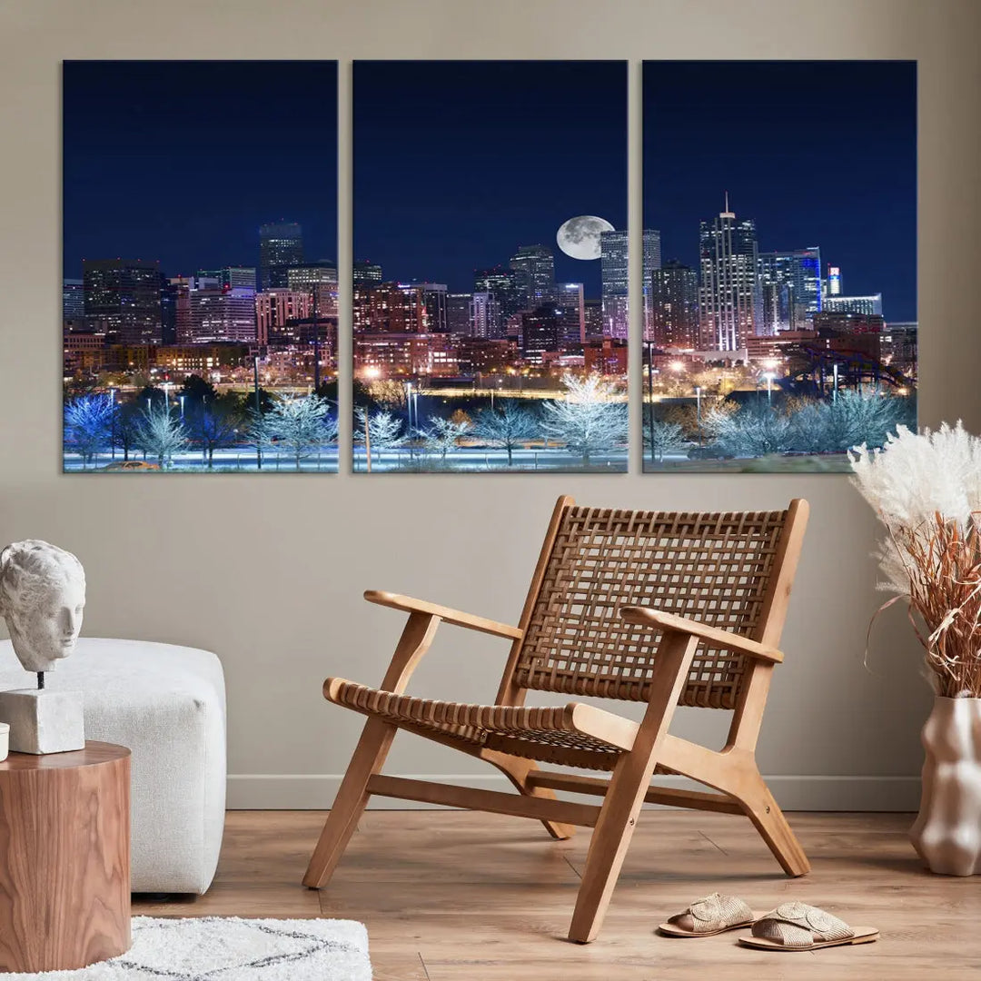 A cozy living room features the "Denver City Lights Night with Full Moon Skyline Cityscape View" wall art canvas print, gallery wrapped on museum-quality canvas.