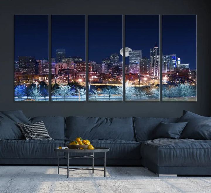 A cozy living room features the "Denver City Lights Night with Full Moon Skyline Cityscape View" wall art canvas print, gallery wrapped on museum-quality canvas.