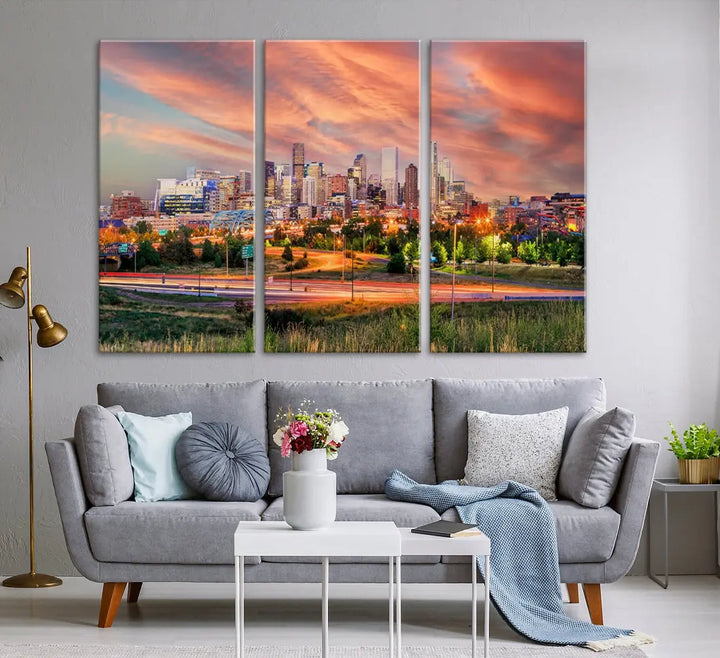 The modern living room showcases the "Denver City Lights Sunset Orange Cloudy Skyline Cityscape View Wall Art Canvas Print," a triptych of museum-quality canvases depicting a city skyline at sunset. This ready-to-hang artwork boasts a UV-protective coating to ensure lasting vibrancy.