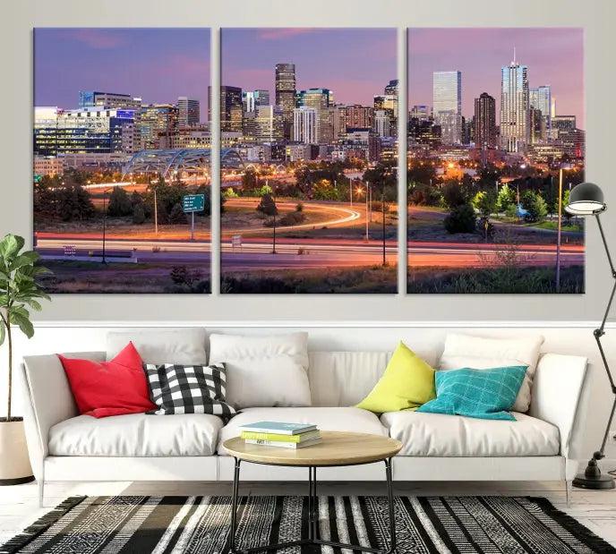 The cozy living room is adorned with a triptych of the "Denver City Lights Sunset Purple Skyline Cityscape View Wall Art Canvas Print." Professionally hand-assembled, these museum-quality canvases bring elegance and sophistication to the space, complemented by the convenience of free shipping.