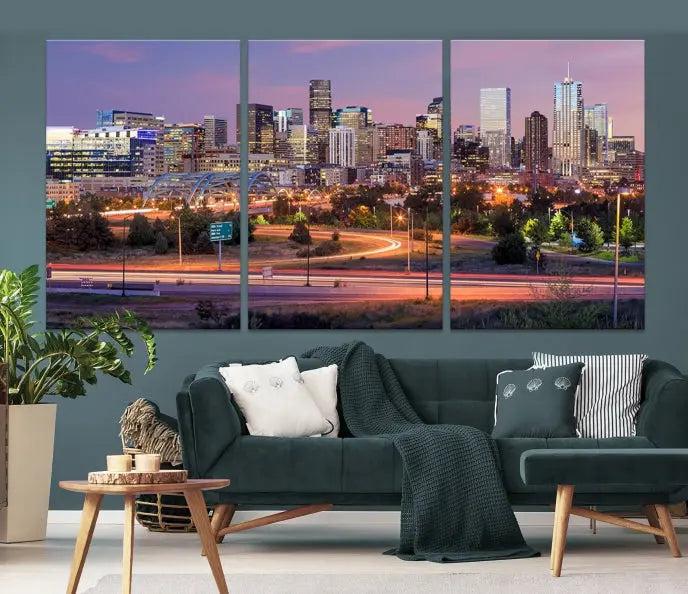 The cozy living room is adorned with a triptych of the "Denver City Lights Sunset Purple Skyline Cityscape View Wall Art Canvas Print." Professionally hand-assembled, these museum-quality canvases bring elegance and sophistication to the space, complemented by the convenience of free shipping.