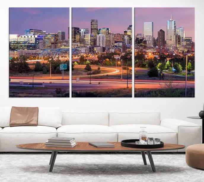 The cozy living room is adorned with a triptych of the "Denver City Lights Sunset Purple Skyline Cityscape View Wall Art Canvas Print." Professionally hand-assembled, these museum-quality canvases bring elegance and sophistication to the space, complemented by the convenience of free shipping.