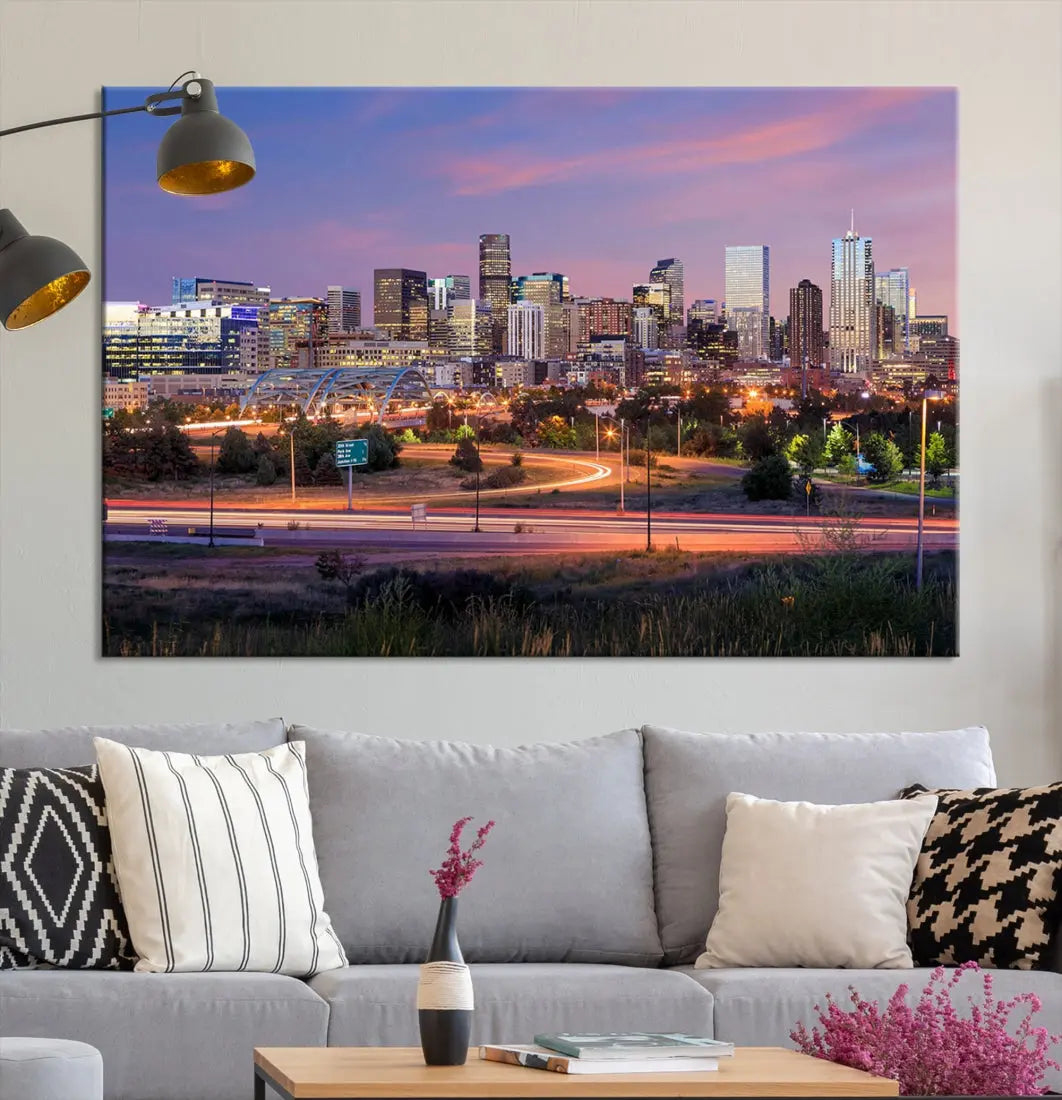 The Denver City Lights Sunset Purple Skyline Cityscape View Wall Art Canvas Print is crafted on museum-quality canvas with a UV-protective coating. It is displayed on a wall.