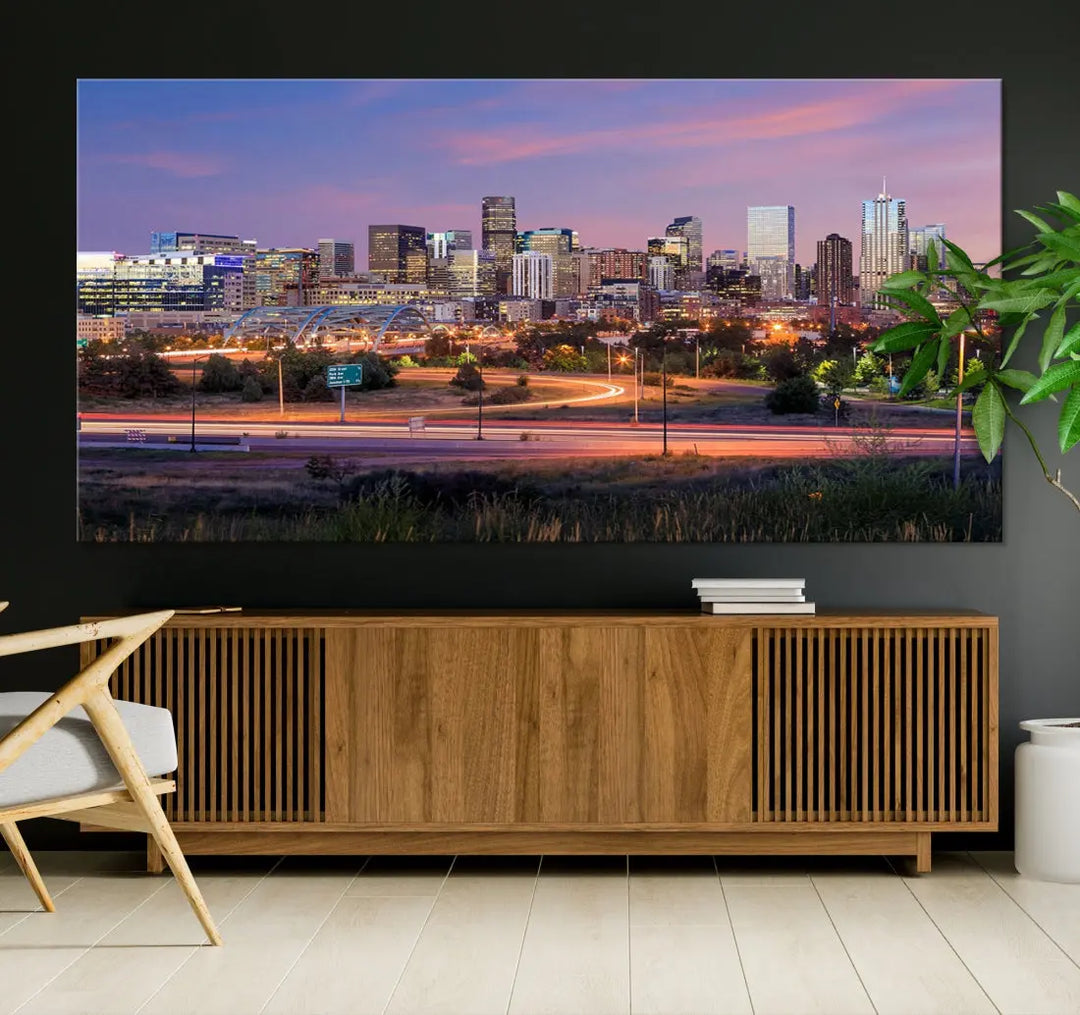 The Denver City Lights Sunset Purple Skyline Cityscape View Wall Art Canvas Print is crafted on museum-quality canvas with a UV-protective coating. It is displayed on a wall.