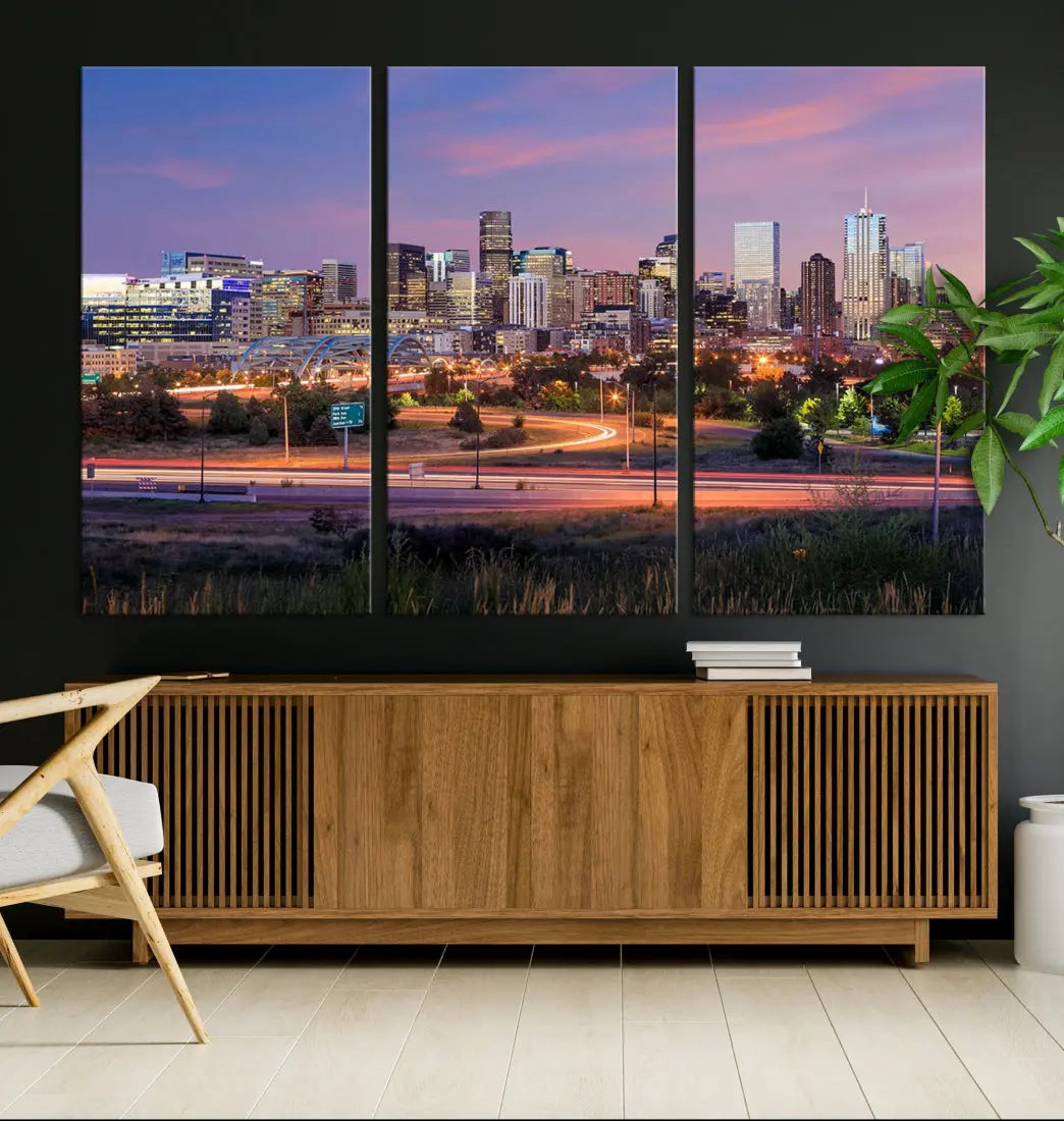 The Denver City Lights Sunset Purple Skyline Cityscape View Wall Art Canvas Print is crafted on museum-quality canvas with a UV-protective coating. It is displayed on a wall.