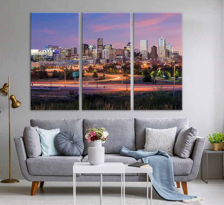 The Denver City Lights Sunset Purple Skyline Cityscape View Wall Art Canvas Print is crafted on museum-quality canvas with a UV-protective coating. It is displayed on a wall.