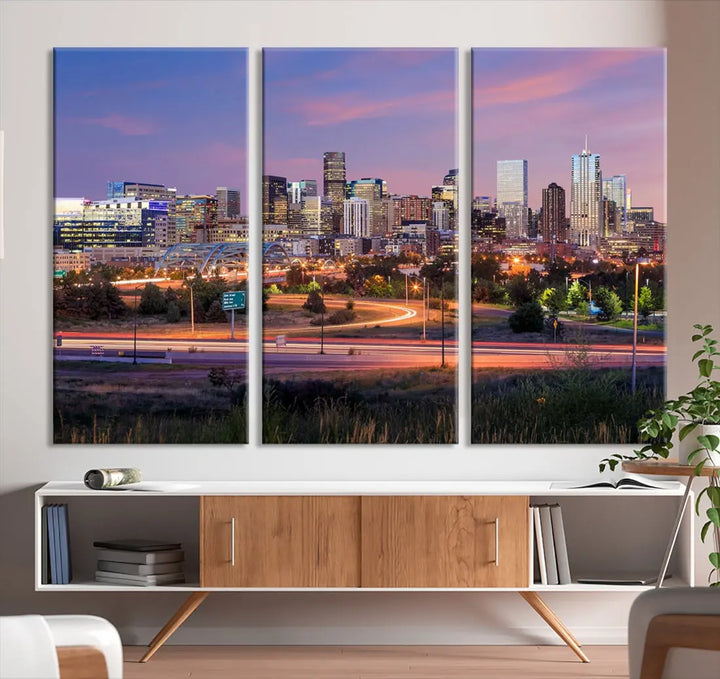 The Denver City Lights Sunset Purple Skyline Cityscape View Wall Art Canvas Print is crafted on museum-quality canvas with a UV-protective coating. It is displayed on a wall.