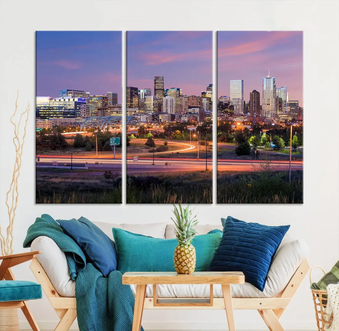 The Denver City Lights Sunset Purple Skyline Cityscape View Wall Art Canvas Print is crafted on museum-quality canvas with a UV-protective coating. It is displayed on a wall.