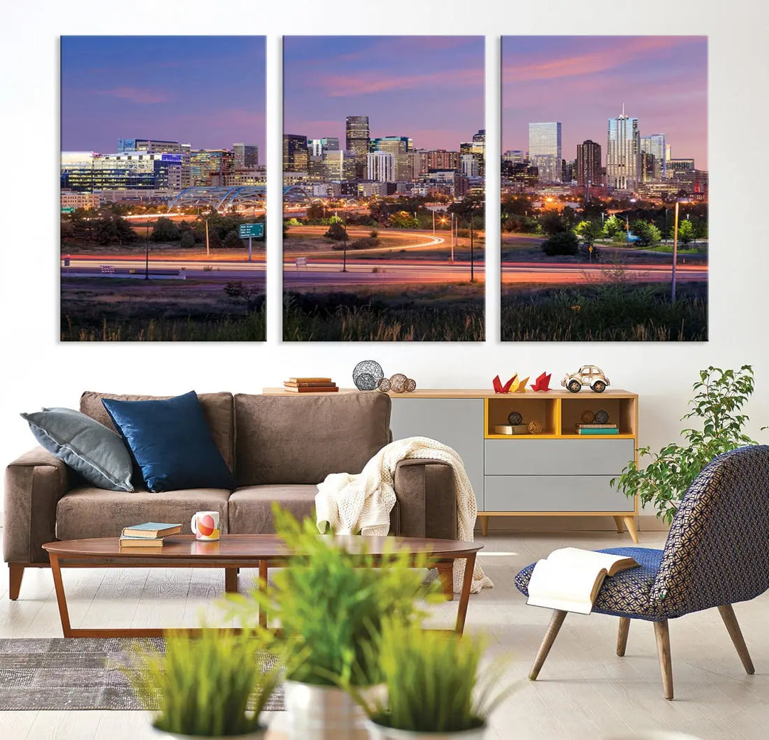 The Denver City Lights Sunset Purple Skyline Cityscape View Wall Art Canvas Print is crafted on museum-quality canvas with a UV-protective coating. It is displayed on a wall.