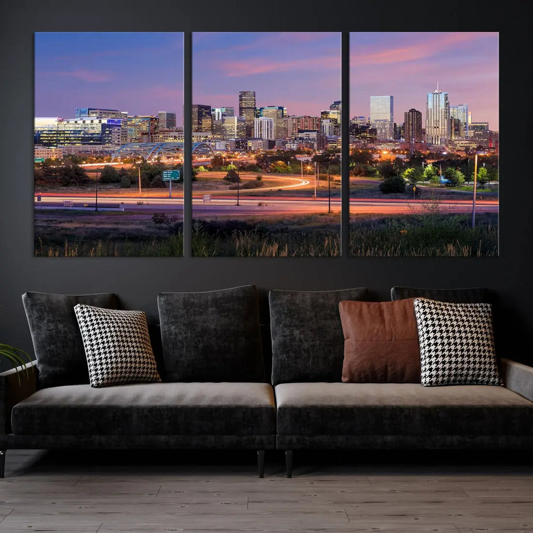 The Denver City Lights Sunset Purple Skyline Cityscape View Wall Art Canvas Print is crafted on museum-quality canvas with a UV-protective coating. It is displayed on a wall.