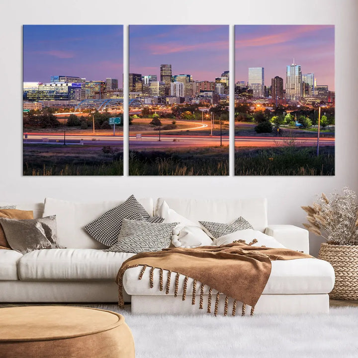 The Denver City Lights Sunset Purple Skyline Cityscape View Wall Art Canvas Print is crafted on museum-quality canvas with a UV-protective coating. It is displayed on a wall.