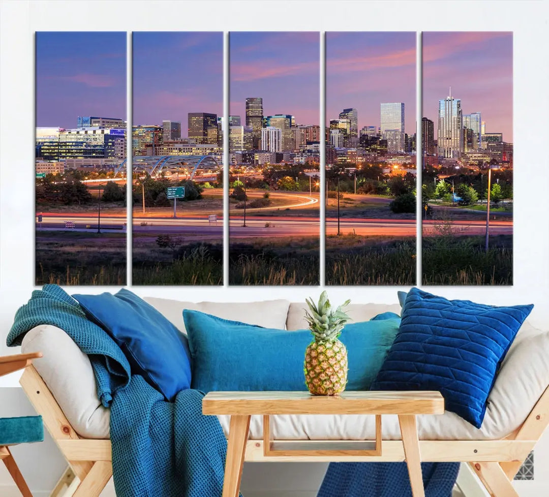 The Denver City Lights Sunset Purple Skyline Cityscape View Wall Art Canvas Print is crafted on museum-quality canvas with a UV-protective coating. It is displayed on a wall.