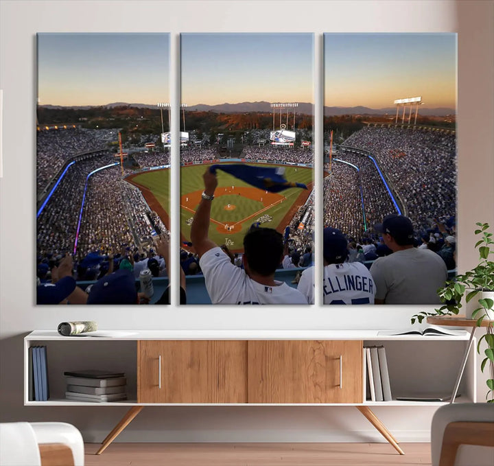 Experience the vibrant moment captured in the Dodger Stadium Sunset Game Triple Canvas Wall Art. This stunning three-panel piece showcases a breathtaking scene from a Los Angeles Dodgers MLB game during sunset, complete with cheering fans in the background.