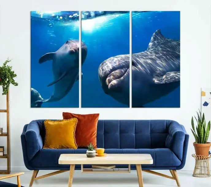 The Dolphin Wall Art Underwater Canvas Print showcases three panels of dolphins swimming underwater, gallery wrapped on museum-quality canvas with UV-protective coating.