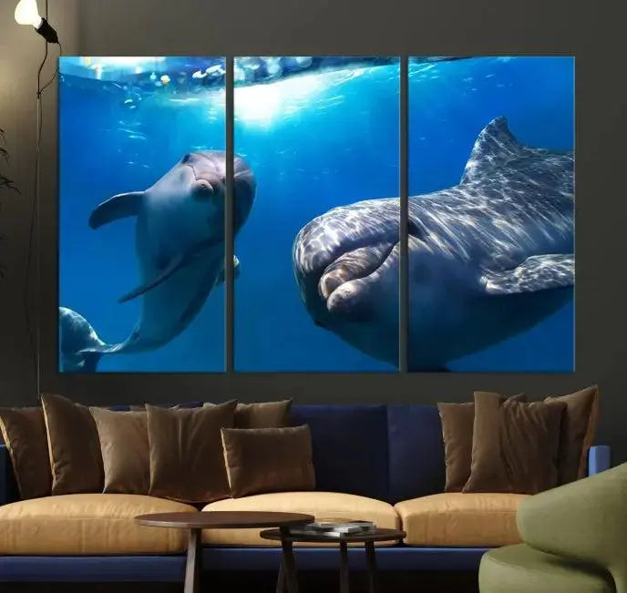 The Dolphin Wall Art Underwater Canvas Print showcases three panels of dolphins swimming underwater, gallery wrapped on museum-quality canvas with UV-protective coating.