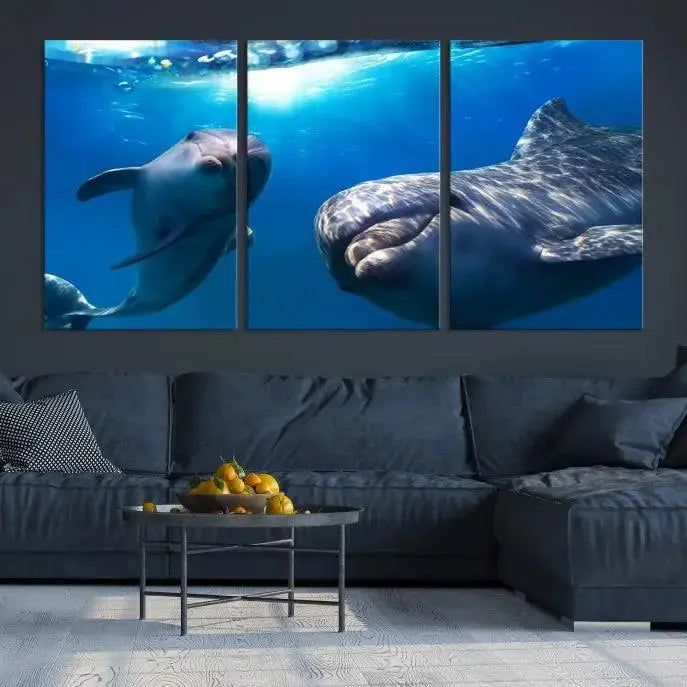 The Dolphin Wall Art Underwater Canvas Print showcases three panels of dolphins swimming underwater, gallery wrapped on museum-quality canvas with UV-protective coating.