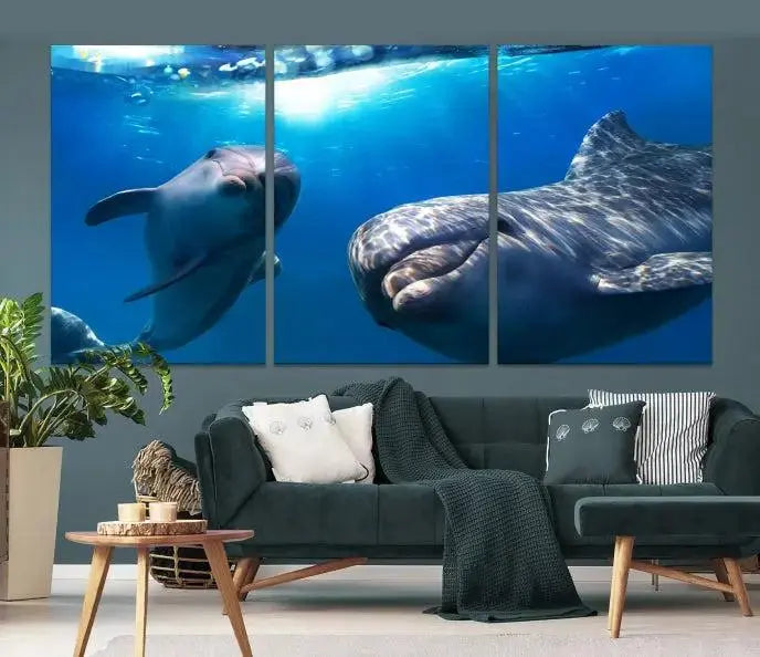 The Dolphin Wall Art Underwater Canvas Print showcases three panels of dolphins swimming underwater, gallery wrapped on museum-quality canvas with UV-protective coating.