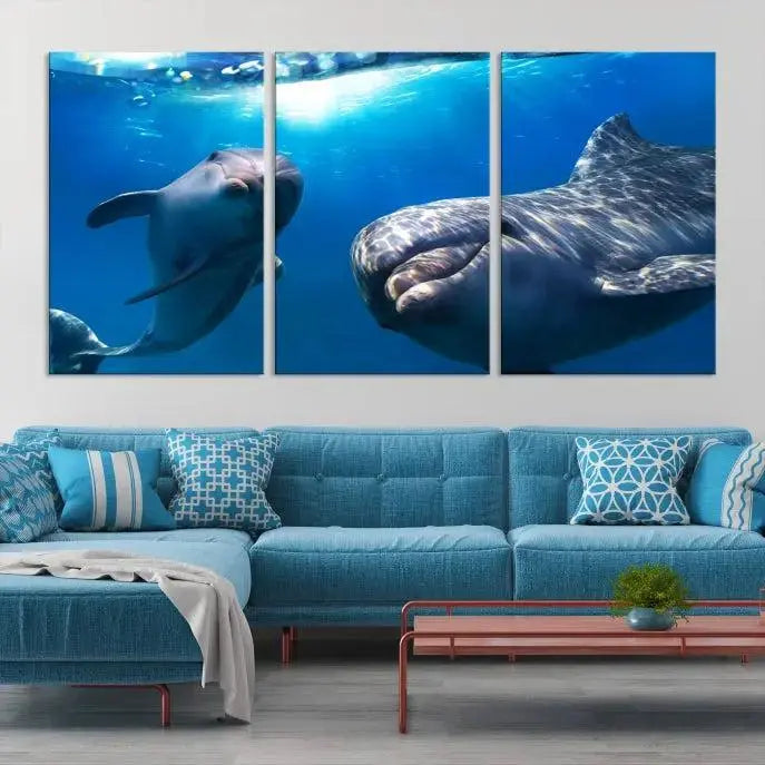 The Dolphin Wall Art Underwater Canvas Print showcases three panels of dolphins swimming underwater, gallery wrapped on museum-quality canvas with UV-protective coating.