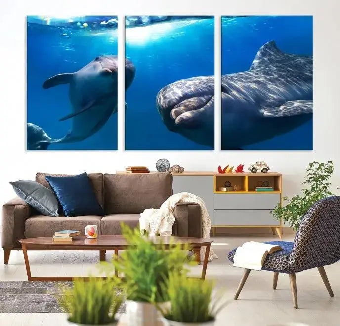 The Dolphin Wall Art Underwater Canvas Print showcases three panels of dolphins swimming underwater, gallery wrapped on museum-quality canvas with UV-protective coating.