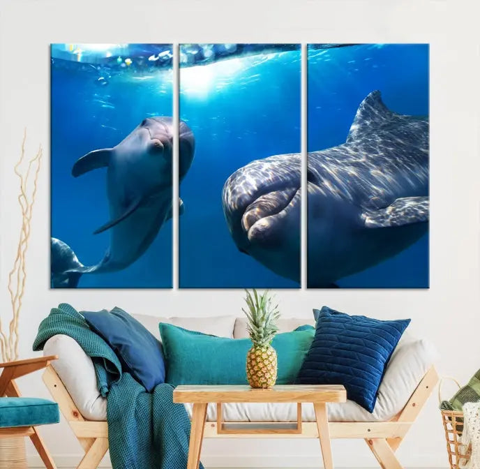 The Dolphin Wall Art Underwater Canvas Print showcases three panels of dolphins swimming underwater, gallery wrapped on museum-quality canvas with UV-protective coating.