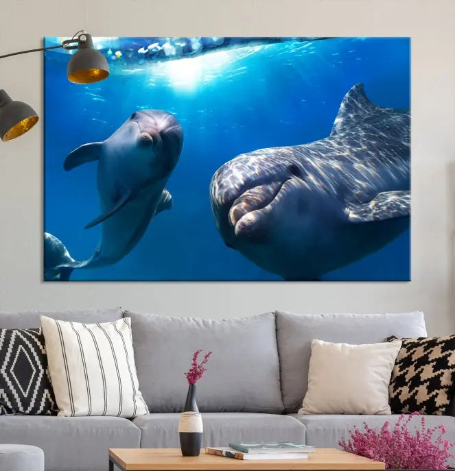 The Dolphin Wall Art Underwater Canvas Print showcases three panels of dolphins swimming underwater, gallery wrapped on museum-quality canvas with UV-protective coating.