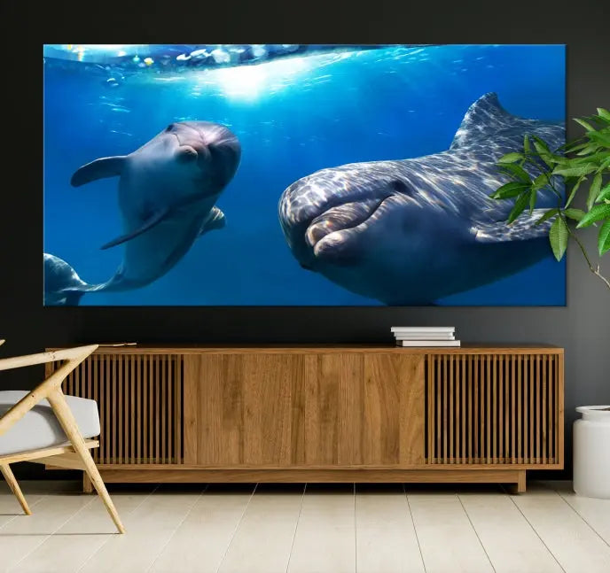 The Dolphin Wall Art Underwater Canvas Print showcases three panels of dolphins swimming underwater, gallery wrapped on museum-quality canvas with UV-protective coating.