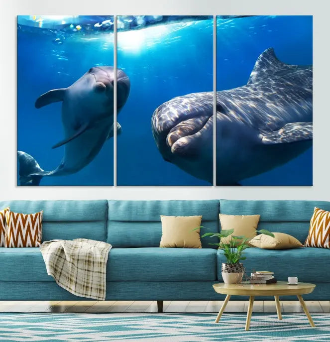 The Dolphin Wall Art Underwater Canvas Print showcases three panels of dolphins swimming underwater, gallery wrapped on museum-quality canvas with UV-protective coating.