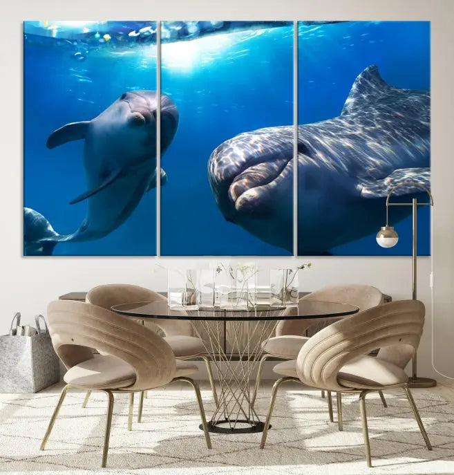 The Dolphin Wall Art Underwater Canvas Print showcases three panels of dolphins swimming underwater, gallery wrapped on museum-quality canvas with UV-protective coating.