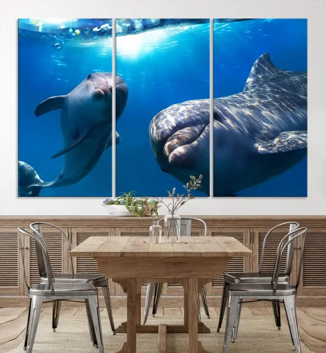 The Dolphin Wall Art Underwater Canvas Print showcases three panels of dolphins swimming underwater, gallery wrapped on museum-quality canvas with UV-protective coating.