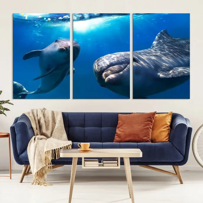 The Dolphin Wall Art Underwater Canvas Print showcases three panels of dolphins swimming underwater, gallery wrapped on museum-quality canvas with UV-protective coating.