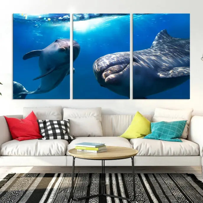 The Dolphin Wall Art Underwater Canvas Print showcases three panels of dolphins swimming underwater, gallery wrapped on museum-quality canvas with UV-protective coating.