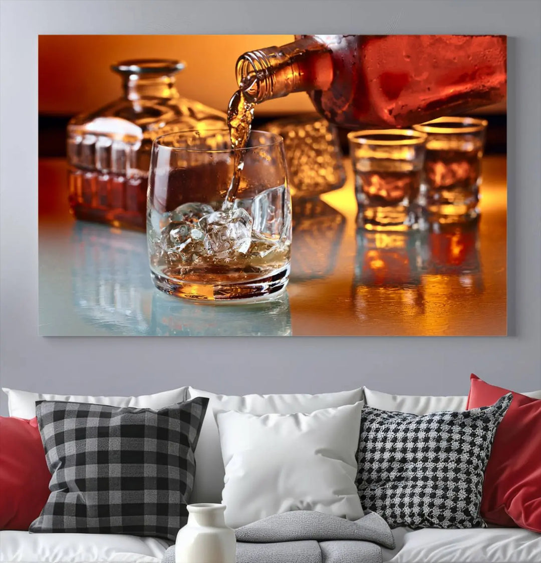 The Elegant Whiskey Canvas Art captures the reflection of a whiskey bottle pouring into an iced glass beside two filled ones.