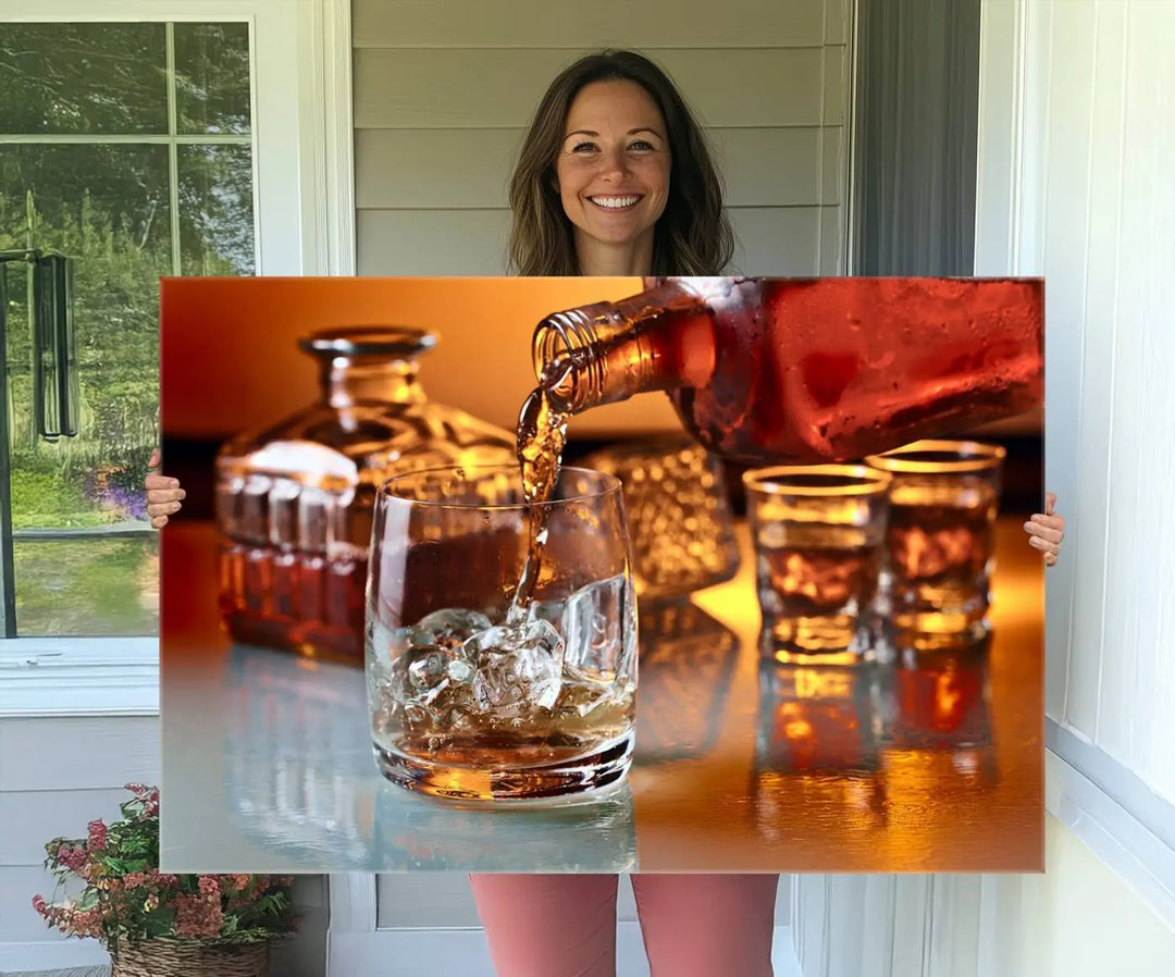 The Elegant Whiskey Canvas Art captures the reflection of a whiskey bottle pouring into an iced glass beside two filled ones.