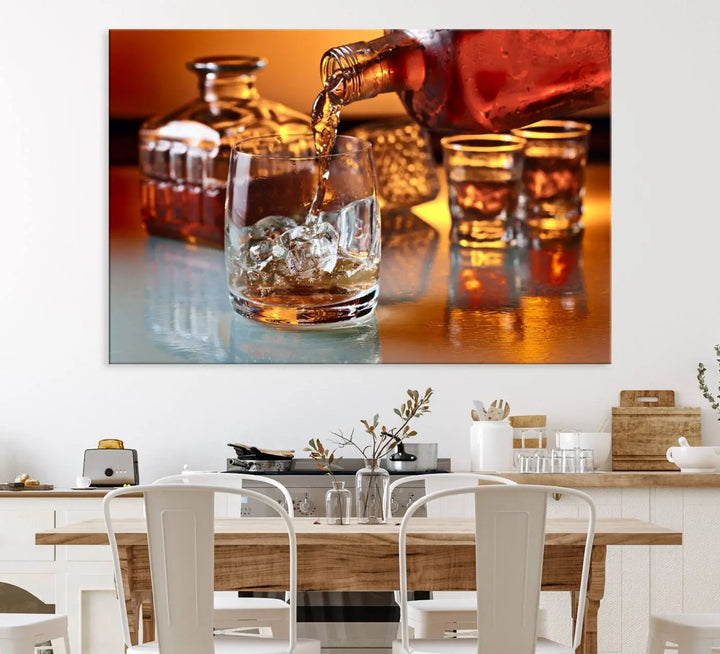 The Elegant Whiskey Canvas Art captures the reflection of a whiskey bottle pouring into an iced glass beside two filled ones.