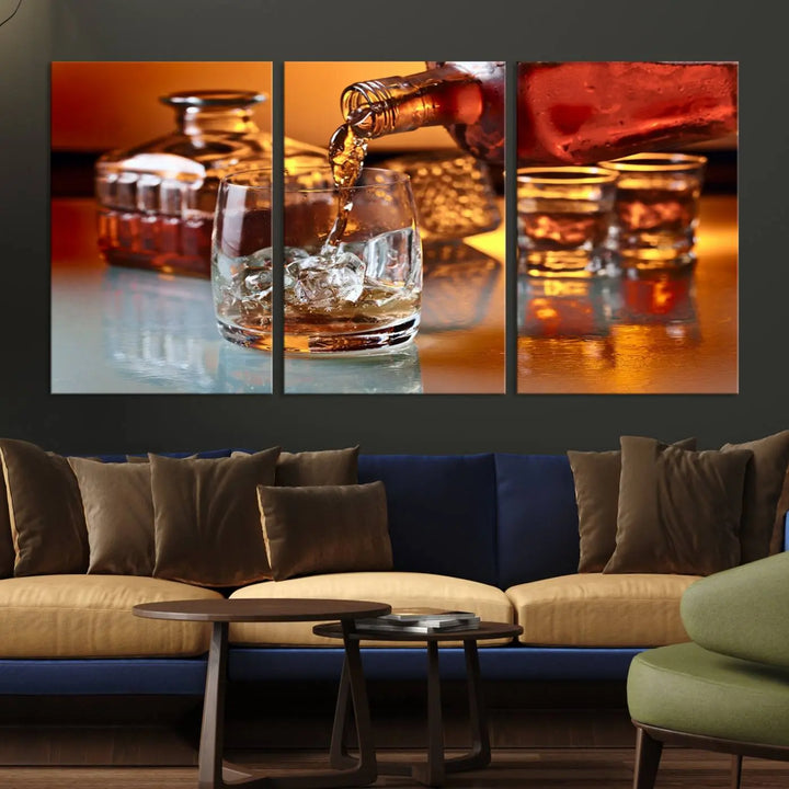 The Elegant Whiskey Canvas Art captures the reflection of a whiskey bottle pouring into an iced glass beside two filled ones.