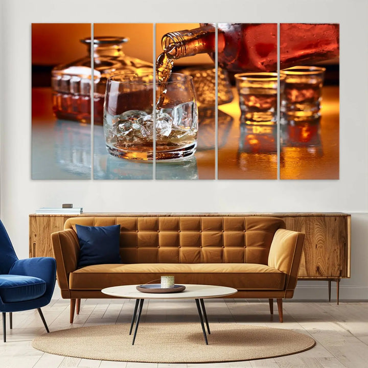 The Elegant Whiskey Canvas Art captures the reflection of a whiskey bottle pouring into an iced glass beside two filled ones.