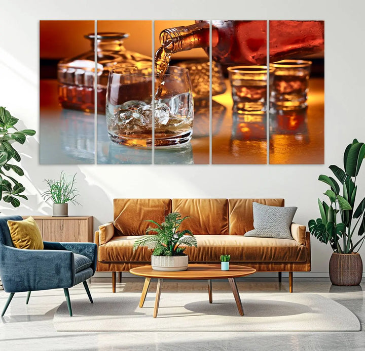 The Elegant Whiskey Canvas Art captures the reflection of a whiskey bottle pouring into an iced glass beside two filled ones.